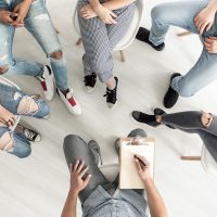 Top view of a group therapy session for teenagers struggling with depression